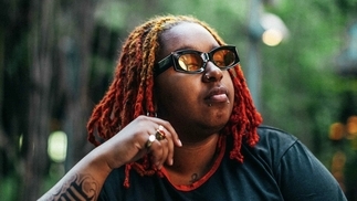 Photo of Fiyahdred wearing orange-lens sunglasses and wearing a black top