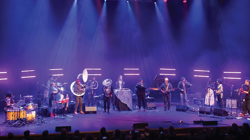 Ensemble of artists affiliated with International Anthem and Total Refreshment Centre performing at the Barbican centre under purple light