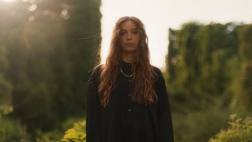 Photo of LP Giobbi standing outside in front of a rural background.