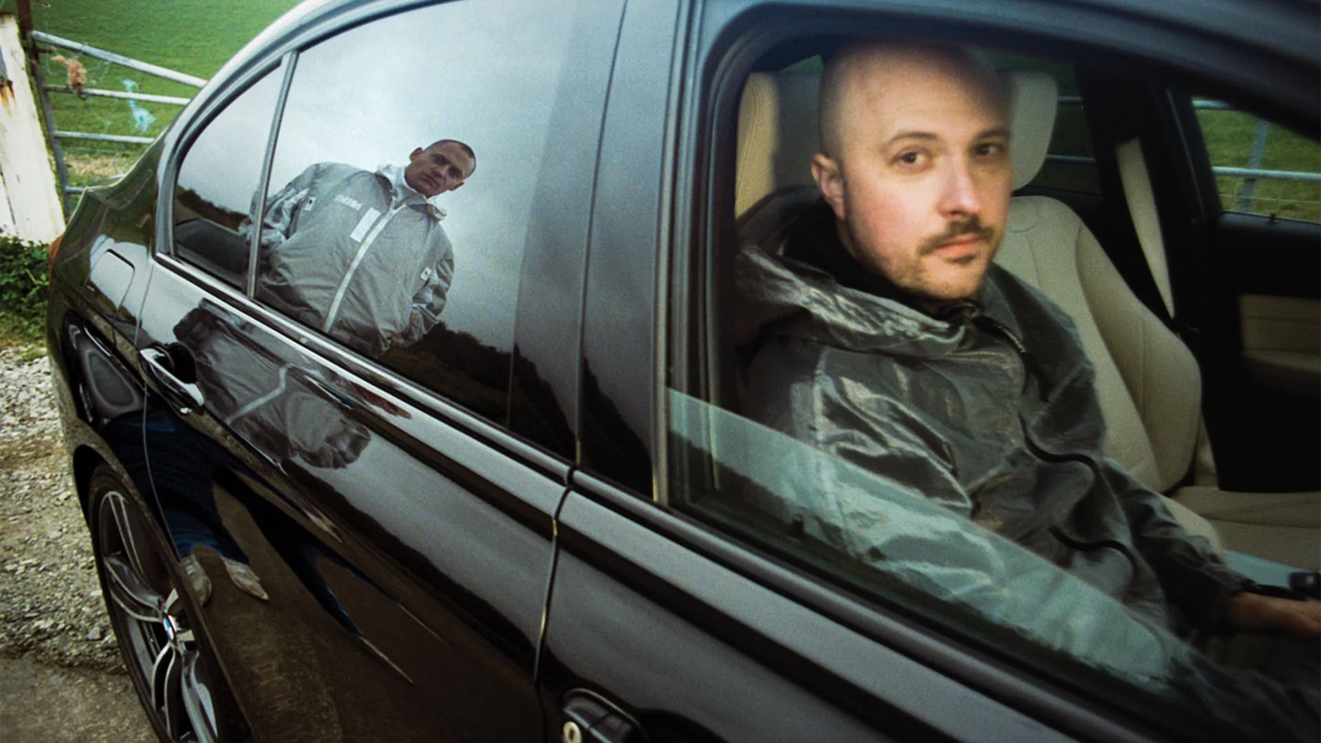 Tom looks out the window of a car to the camera, by Rollo Jackson