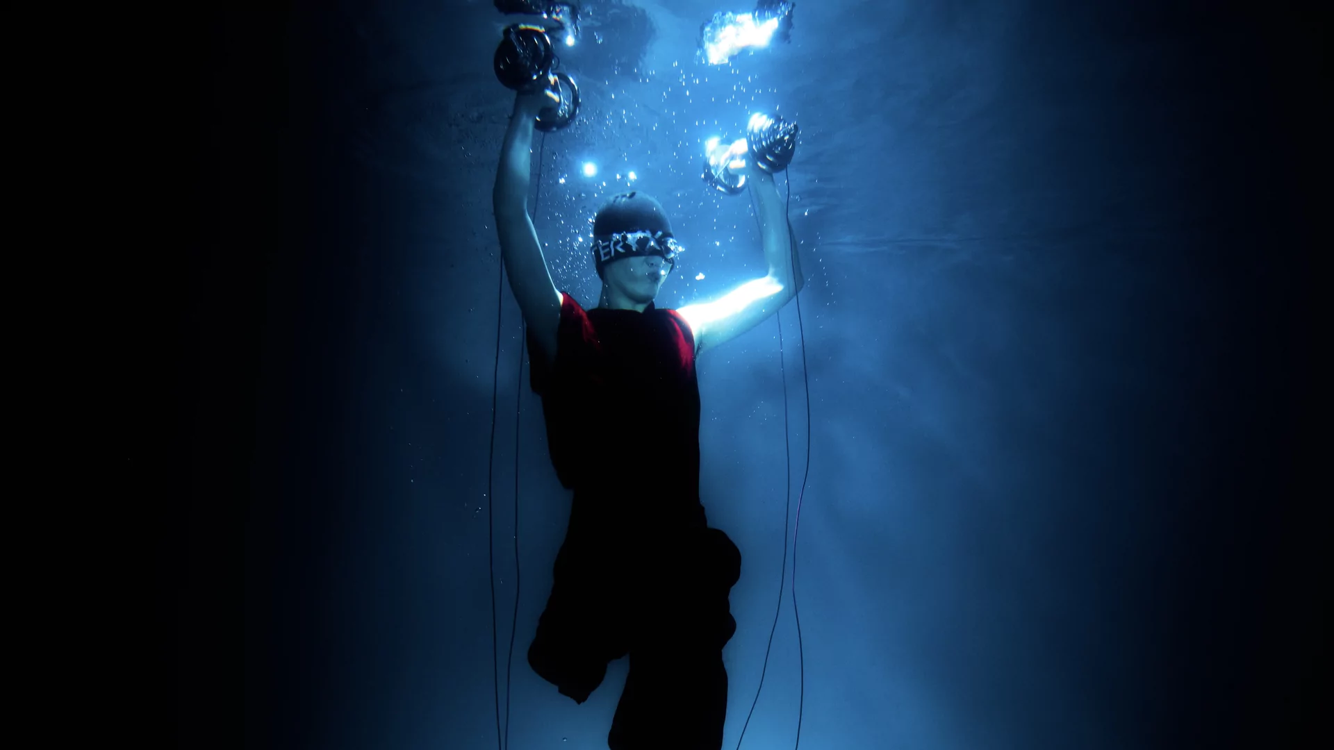 Photo of Tzusing underwater holding dumbbells above his head